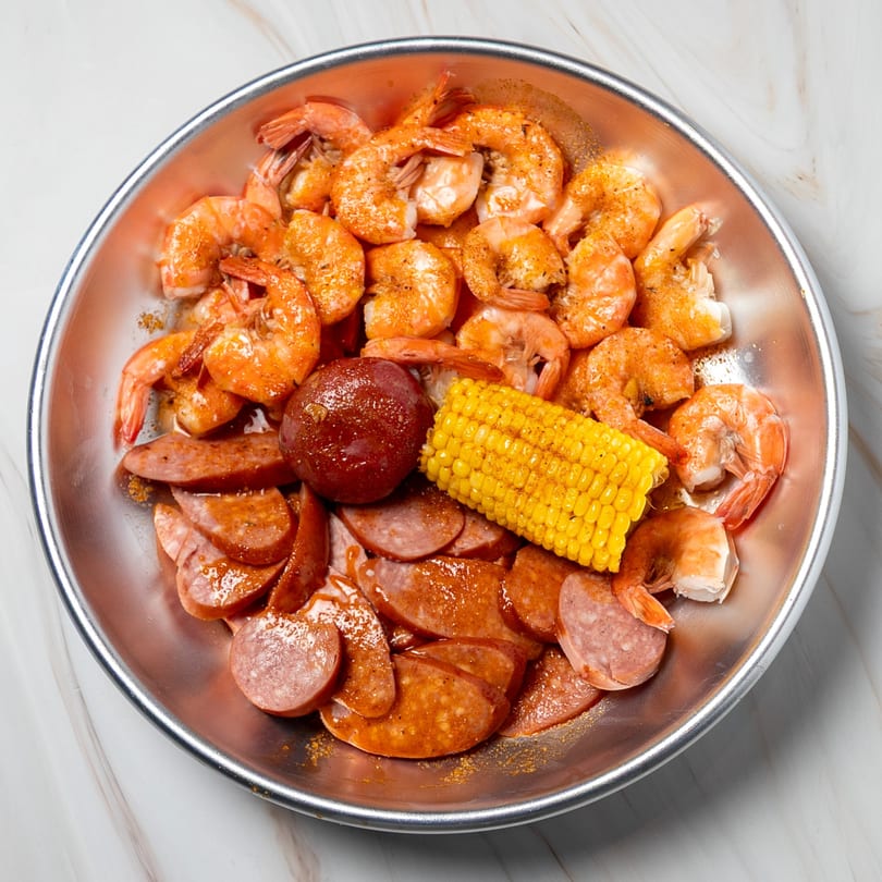 Shake Shake Seafood Monroe's shrimp, sausage, corn on the cob, and potato in a metal bowl.